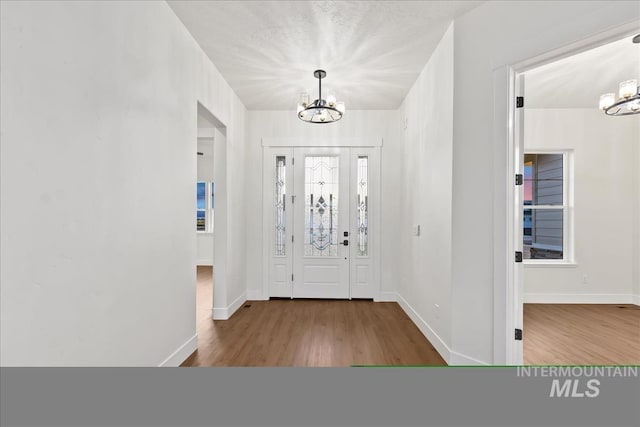 entrance foyer featuring hardwood / wood-style floors and an inviting chandelier