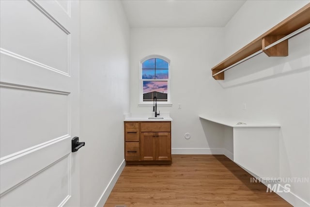 laundry room with sink and light hardwood / wood-style flooring