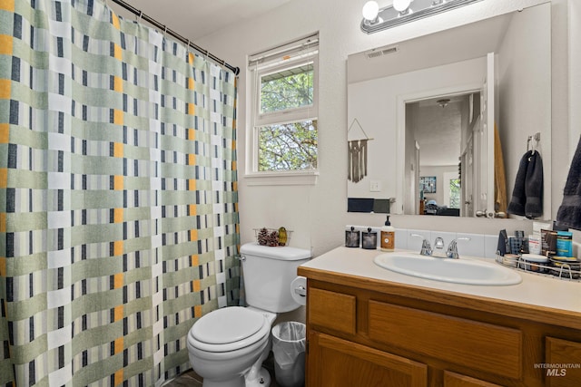 full bath with visible vents, toilet, vanity, and a shower with curtain