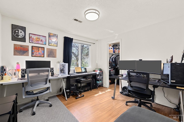 office with wood finished floors and visible vents