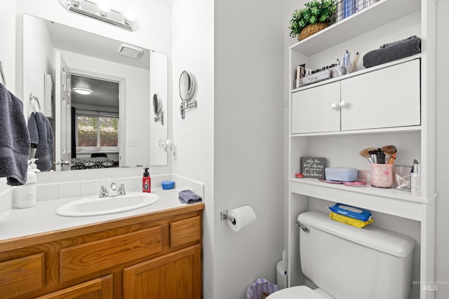 bathroom featuring toilet and vanity
