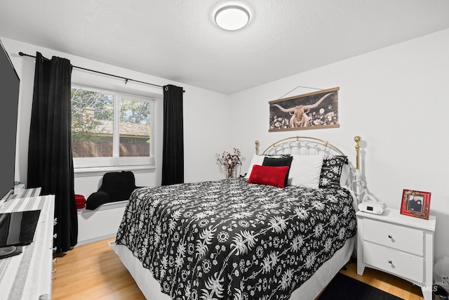 bedroom with light wood-style flooring and a textured ceiling