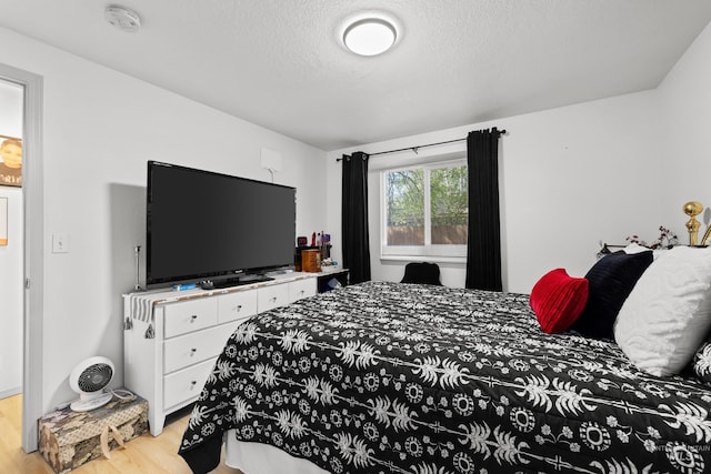 bedroom featuring wood finished floors and a textured ceiling
