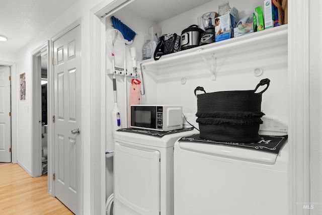 laundry room with light wood-style floors, independent washer and dryer, and laundry area