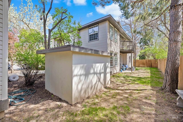 view of property exterior with a fenced backyard and a balcony