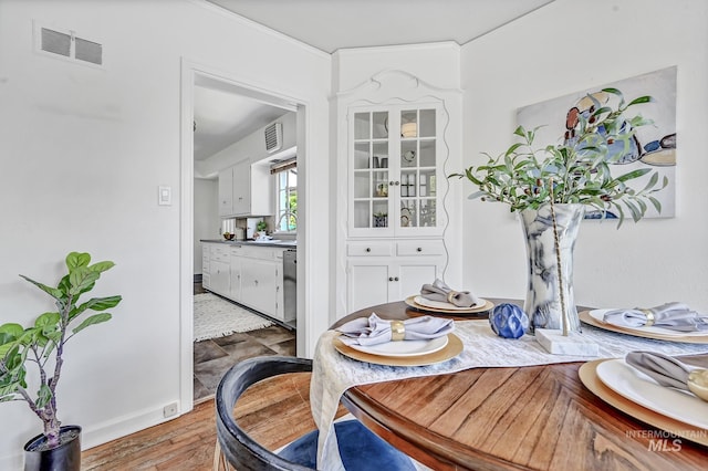 dining space featuring visible vents and wood finished floors