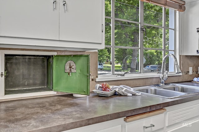 room details featuring dark countertops, white cabinets, and a sink