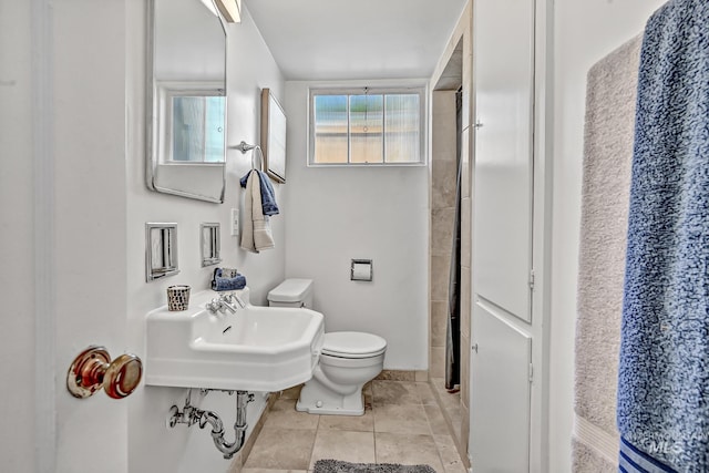 full bath with tile patterned floors, toilet, and a sink