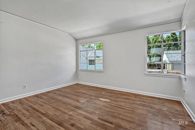 empty room with baseboards and wood-type flooring