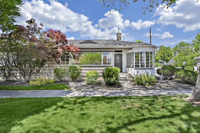 view of front of house featuring cooling unit and a front yard