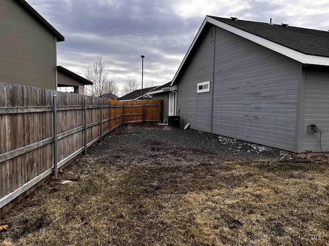 view of side of property with fence and central AC