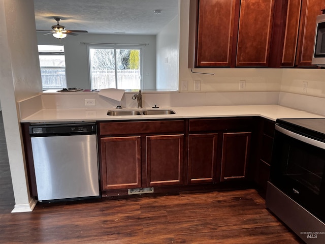 kitchen featuring dark wood-style flooring, appliances with stainless steel finishes, light countertops, and a sink