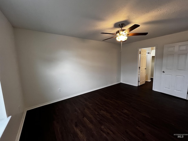 unfurnished bedroom with a ceiling fan, a textured ceiling, baseboards, and dark wood-type flooring