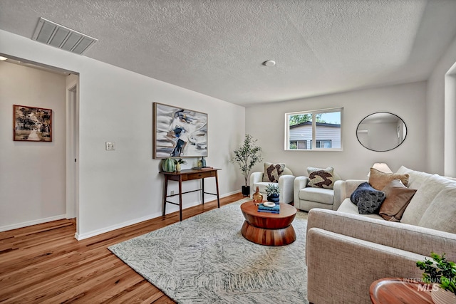 living room with hardwood / wood-style floors and a textured ceiling