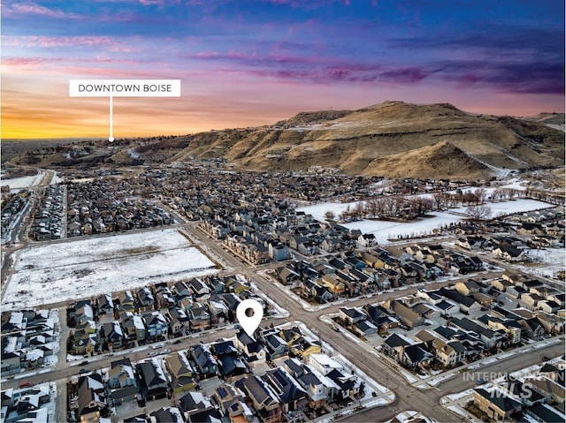 snowy aerial view featuring a residential view and a mountain view