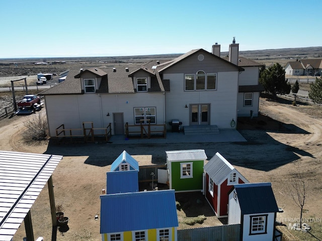 back of house with a chimney and a patio