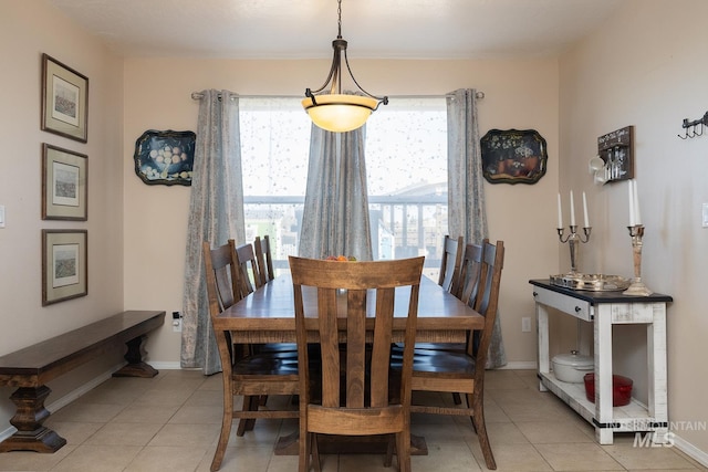 dining area featuring light tile patterned floors and baseboards