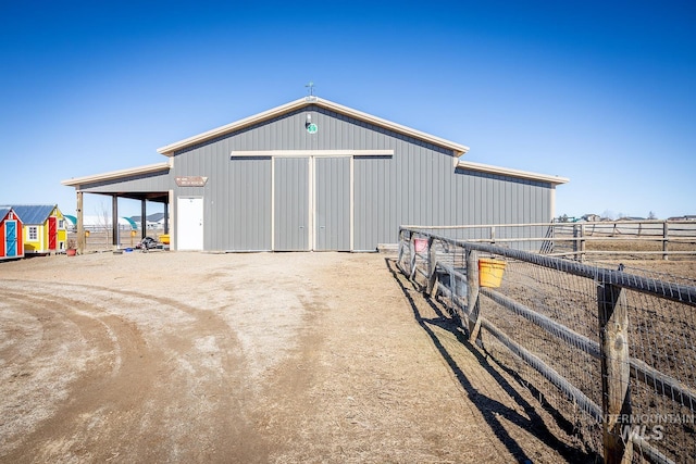 view of outdoor structure featuring driveway, an exterior structure, and an outdoor structure