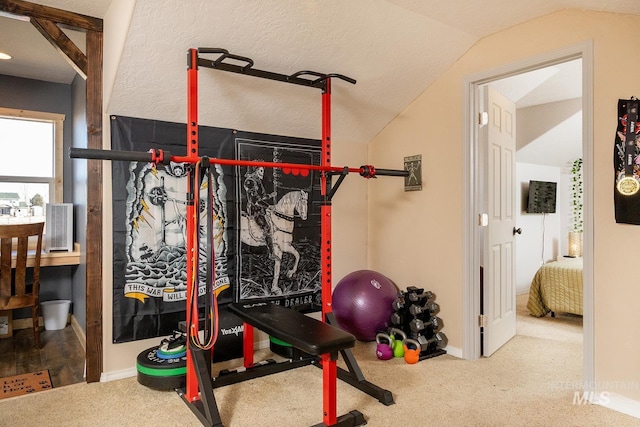 exercise room featuring vaulted ceiling, carpet flooring, and baseboards