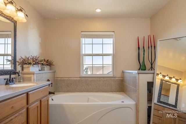 full bath with vanity and a bath