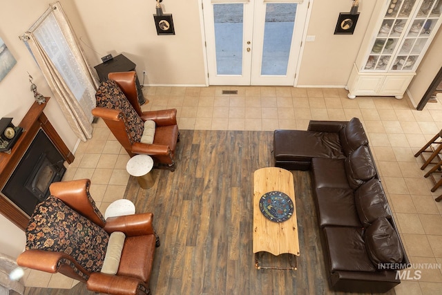 tiled living area featuring baseboards and french doors