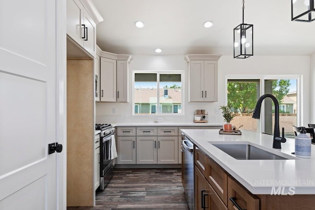 kitchen with stainless steel appliances, light countertops, a healthy amount of sunlight, and a sink