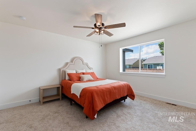 bedroom with a ceiling fan, carpet flooring, visible vents, and baseboards