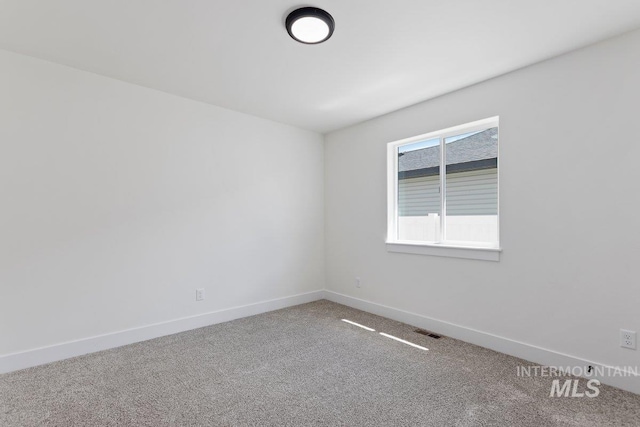 empty room featuring baseboards, visible vents, and carpet flooring