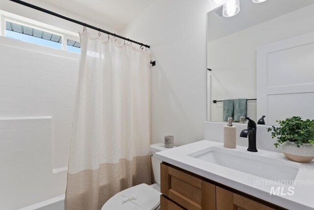 bathroom featuring shower / tub combo with curtain, vanity, and toilet