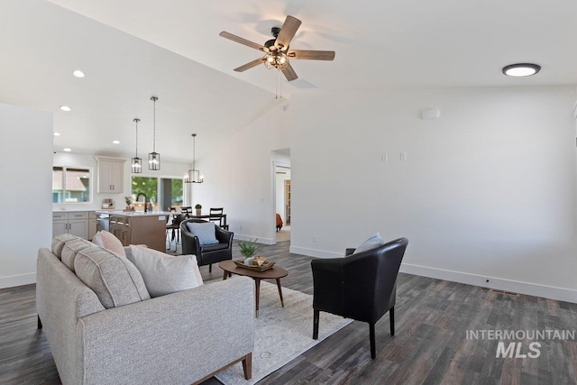 living area with dark wood-style floors, lofted ceiling, recessed lighting, a ceiling fan, and baseboards