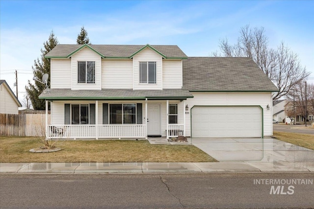 view of front property with a garage, a front yard, and covered porch