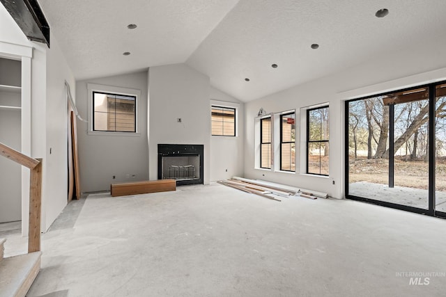 unfurnished living room featuring a textured ceiling, light colored carpet, and vaulted ceiling