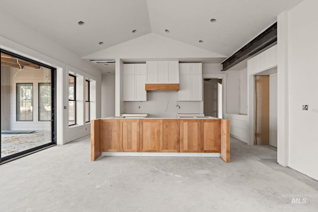 kitchen with white cabinets, custom range hood, a center island with sink, and vaulted ceiling