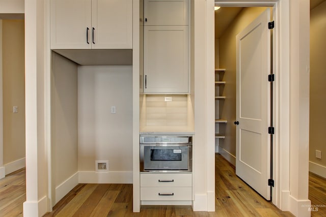 1149 E Crescendo St, Meridian, ID 83642 - kitchen featuring oven, light wood-type flooring, backsplash, and white cabinets
