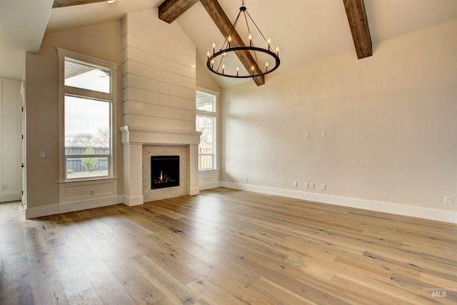 1149 E Crescendo St, Meridian, ID 83642 - unfurnished living room featuring beam ceiling, a chandelier, hardwood / wood-style floors, healthy amount of natural light, and high vaulted ceiling