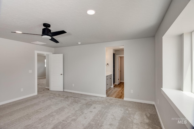 spare room featuring ceiling fan and light colored carpet