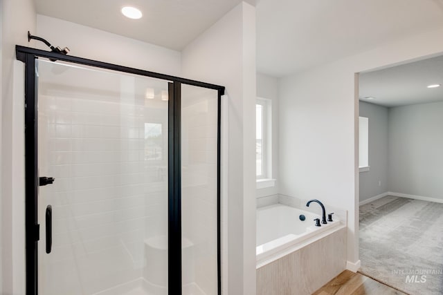 bathroom featuring hardwood / wood-style floors and independent shower and bath