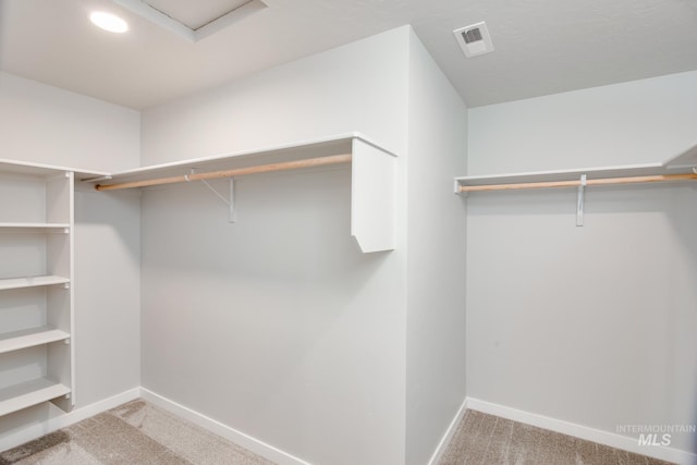 walk in closet featuring light colored carpet