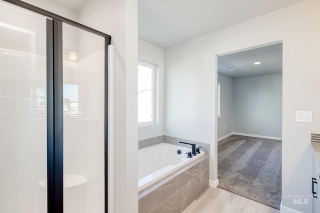 bathroom with wood-type flooring and independent shower and bath