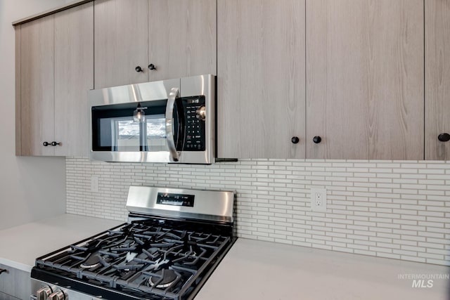 kitchen with decorative backsplash, light brown cabinets, and stainless steel appliances