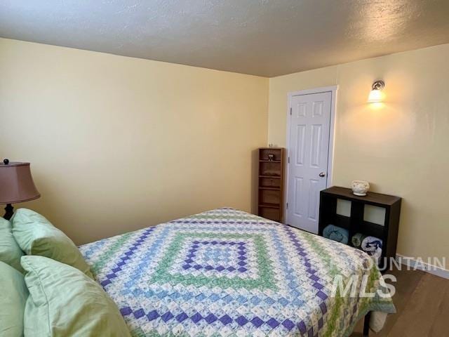 bedroom with hardwood / wood-style floors and a textured ceiling