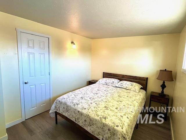 bedroom with dark wood-type flooring