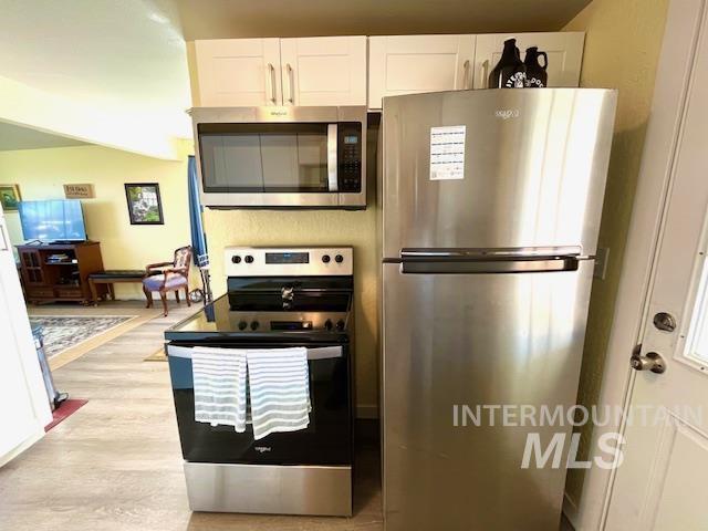 kitchen with white cabinetry, appliances with stainless steel finishes, and light wood-type flooring