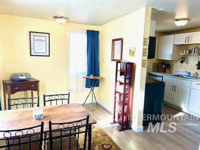 dining area featuring sink and light hardwood / wood-style flooring