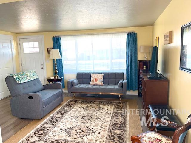 living room with hardwood / wood-style floors and a textured ceiling