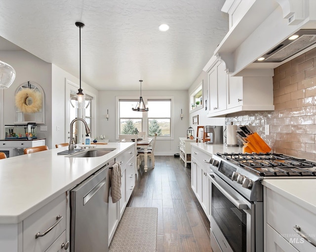 kitchen featuring tasteful backsplash, appliances with stainless steel finishes, light countertops, and a sink