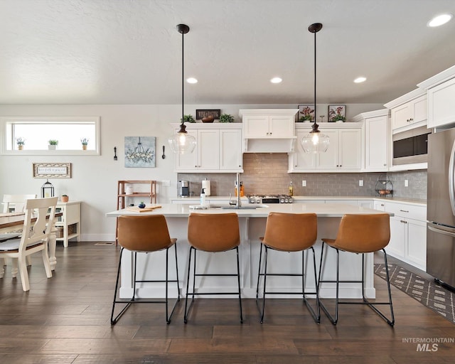 kitchen featuring white cabinetry, light countertops, and freestanding refrigerator