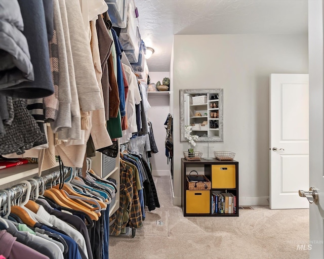 walk in closet with carpet flooring