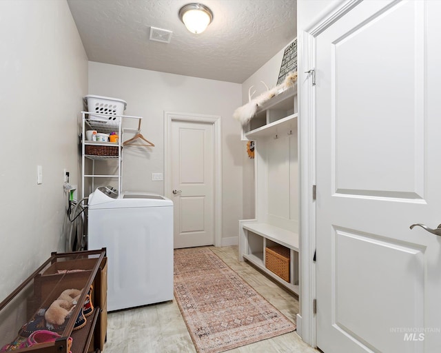 mudroom with visible vents, washer / dryer, a textured ceiling, and wood finished floors