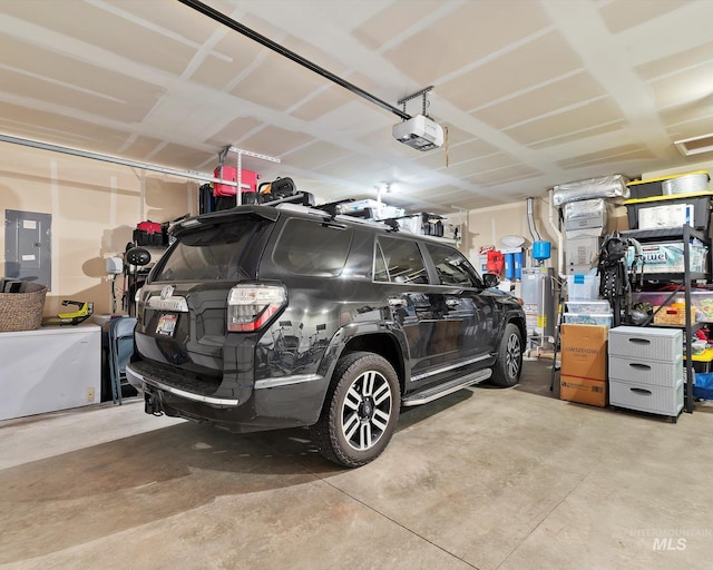 garage featuring electric panel, a garage door opener, and water heater